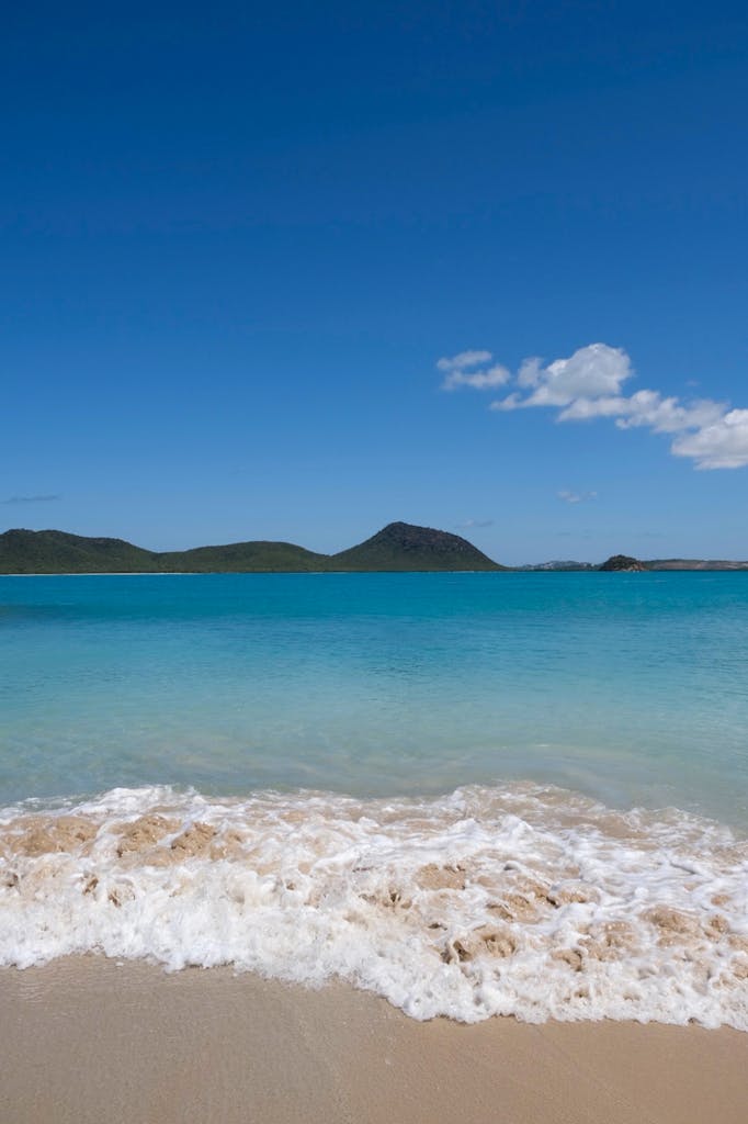 Tranquil view of Saint John's beach with gentle waves and clear skies in Antigua and Barbuda.